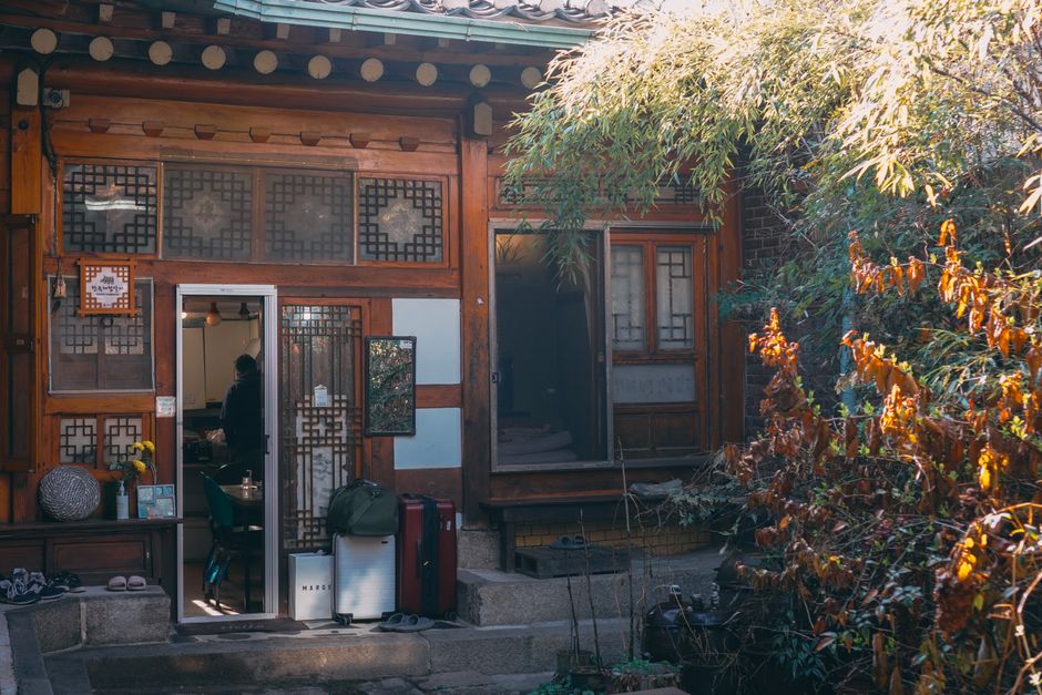전주 한옥마을 내 고즈넉한 전통 한옥 숙소의 내부 전경. 따뜻한 온돌방과 한지 창문 너머로 보이는 평화로운 마당이 인상적이며, 편의를 위한 현대적인 요소가 조화롭게 배치되어 있습니다.