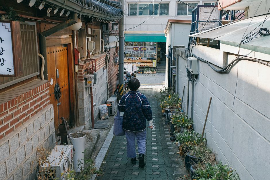 한복을 입은 연인이 전주 한옥마을의 아름다운 골목길에서 경기전이나 전동성당을 배경으로 기념사진을 촬영하는 모습. 전통과 추억이 어우러진 순간을 담고 있습니다.