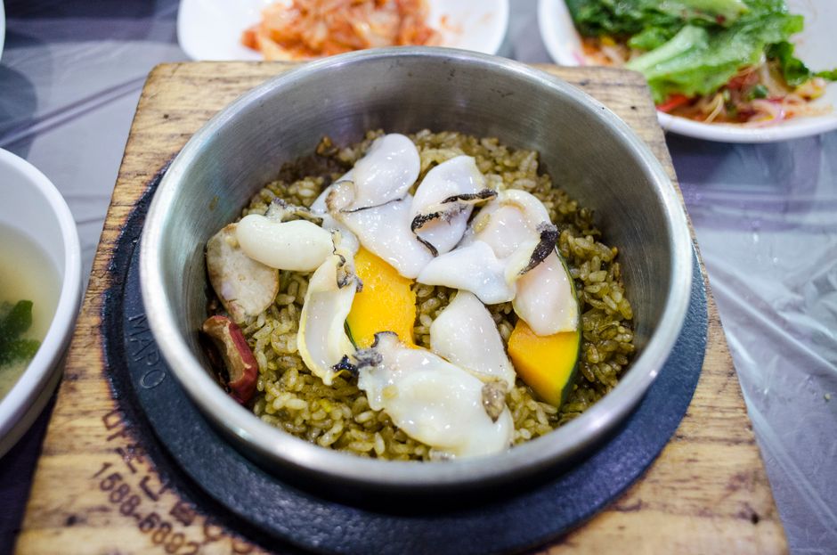 제주 바다를 배경으로 신선한 전복 요리들이 먹음직스럽게 차려진 모습. 제주의 미식 향연을 담은 사진.