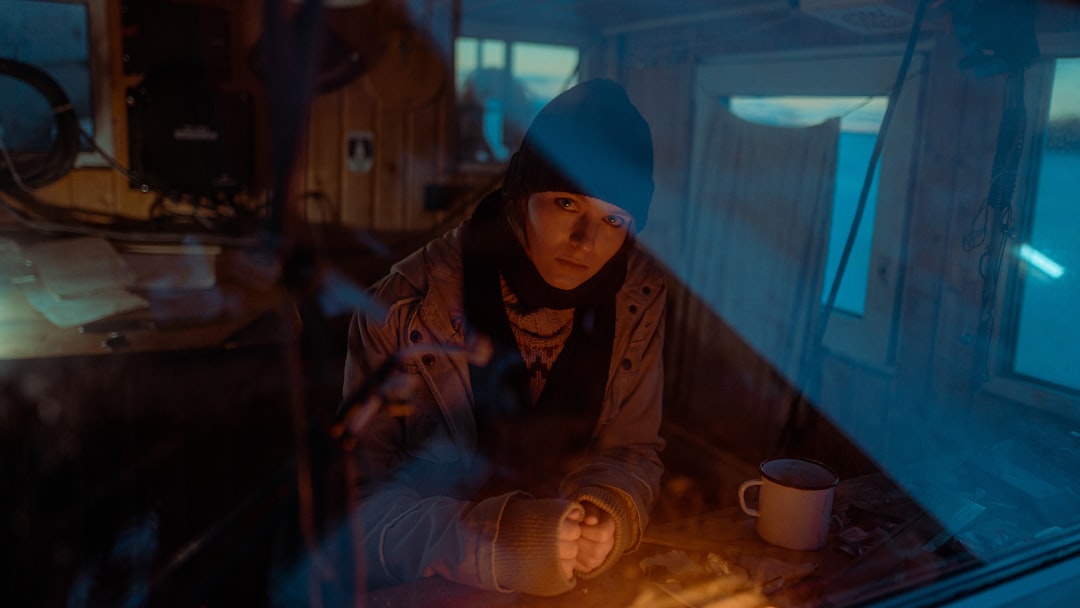 캠핑 스토브 또는 RV 전기 연결부를 돋보기로 꼼꼼히 확인하는 사람의 모습. 캠핑 장비의 품질 기준과 RV 전기 규정 준수의 중요성을 강조한다.